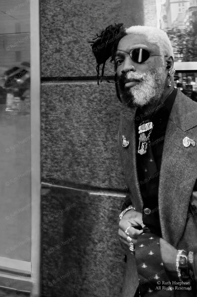 Street portrait of a man with split black-and-white hair and beard
